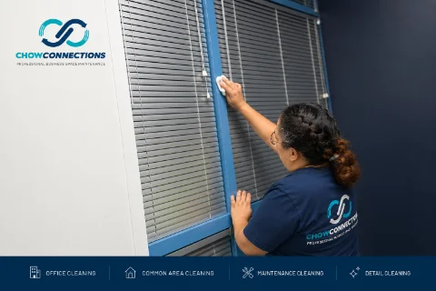 Chow Connections crew member detailing window blinds during a scheduled office cleaning visit