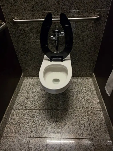 Restroom stall in an Indianapolis commercial facility after cleaning: stall floor cleared and toilet cleaned