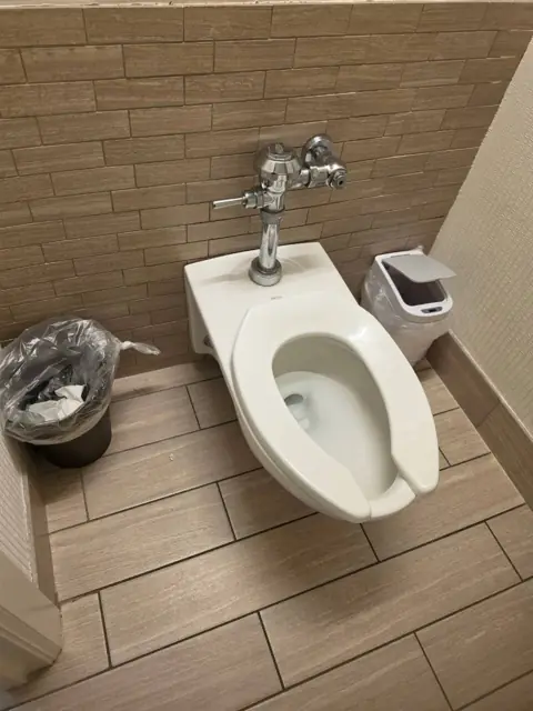 Restroom stall in an Indianapolis commercial facility before cleaning: soiled floor and fixture area